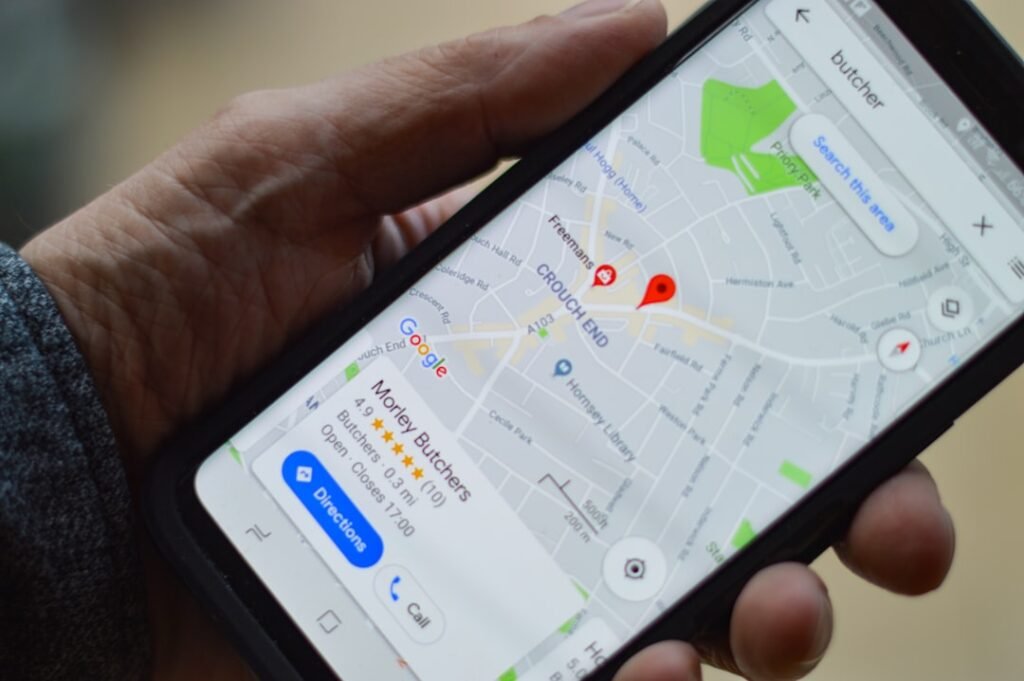 A person holding a smartphone displaying a map and location pin