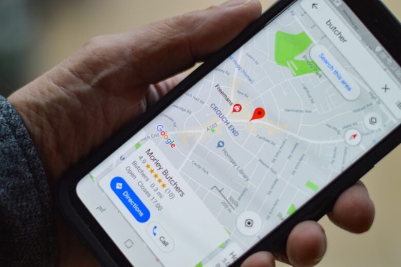 A person holding a smartphone displaying a map and location pin