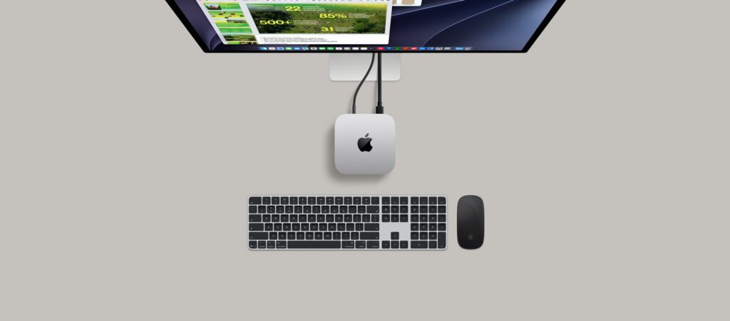 Silver Apple M6 Mac mini beside a Studio Display and Magic Keyboard
