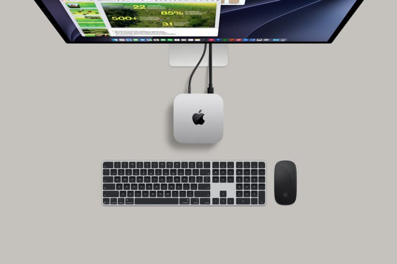 Silver Apple M6 Mac mini beside a Studio Display and Magic Keyboard