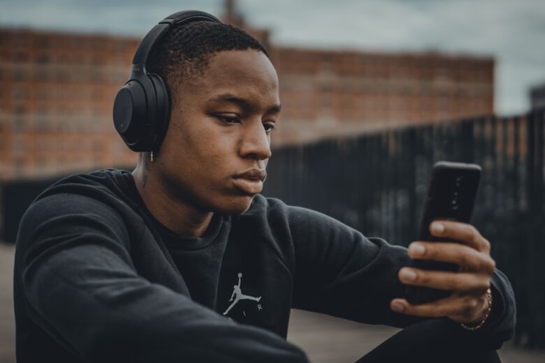Person listening with headphones and a smartphone for Bluetooth audio troubleshooting