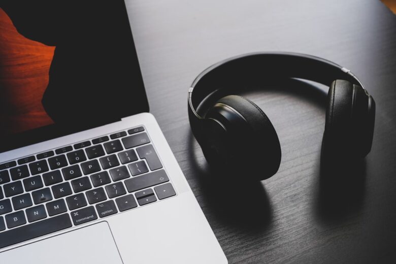 Headphones beside a laptop illustrating audio call quality comparison