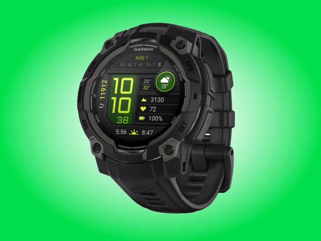 Garmin Instinct 3 AMOLED product image with a black case and strap against a green background
