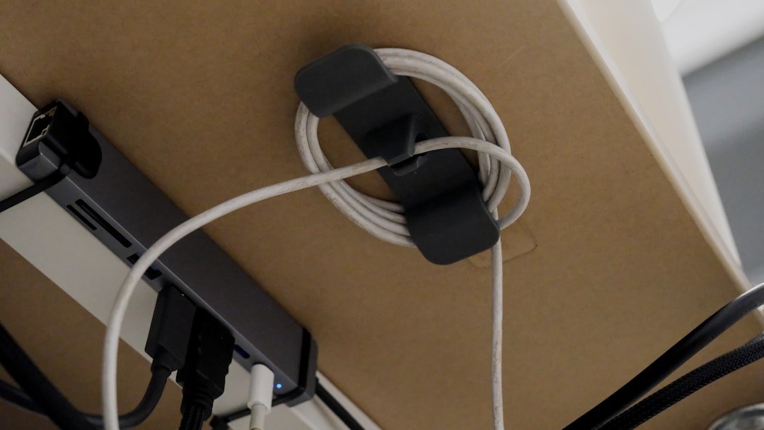 Coiled electrical cord held in an organizer underneath a desk