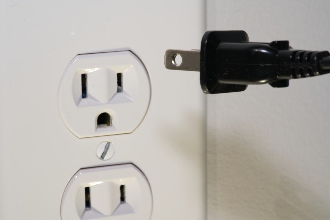 Close-up of an electrical plug connected to a wall outlet