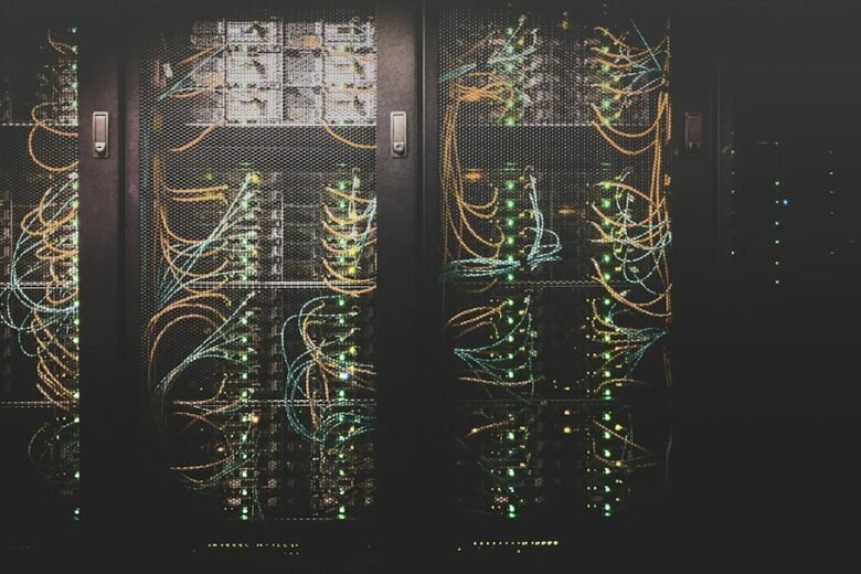 Server and networking equipment with cables and indicator lights behind rack doors