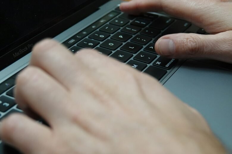 Person typing on a laptop while evaluating it before purchase