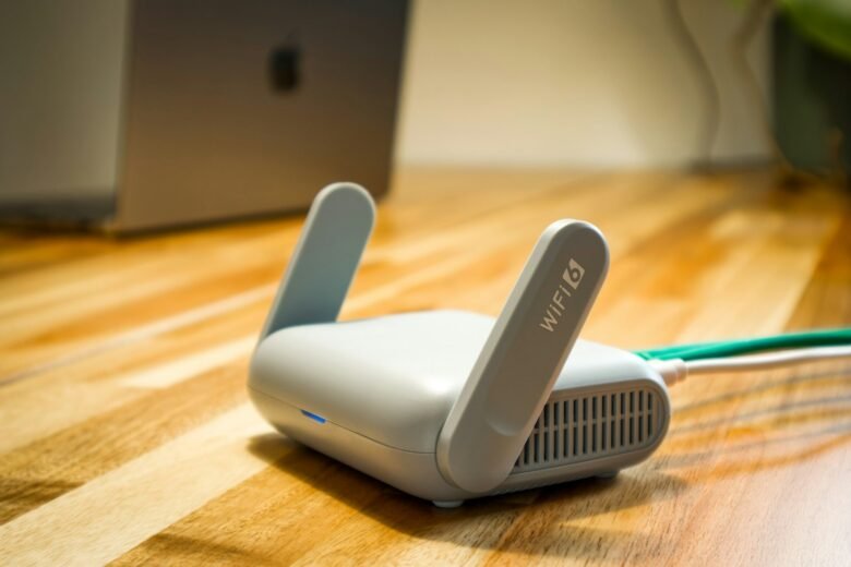 Wi-Fi router standing in the open on a desk with Ethernet and power cables connected
