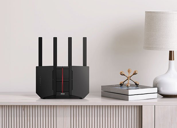 Black ASUS RT-BE92U Wi-Fi router with four antennas on a wooden table