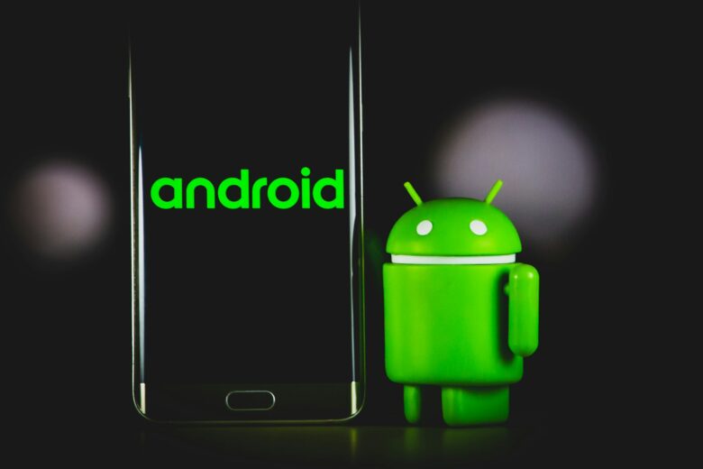 Android mascot beside a smartphone; illustrative photo