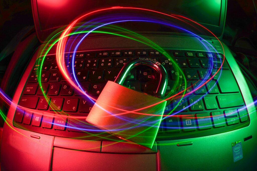 Padlock resting on a laptop keyboard with colored light trails