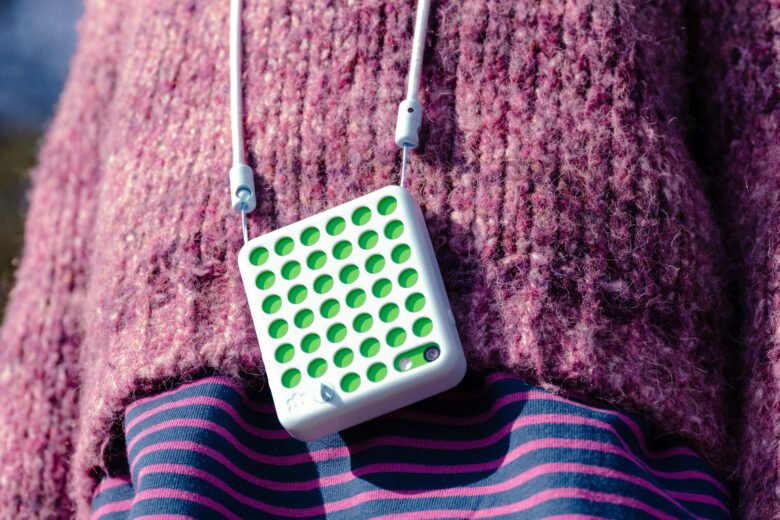 A child wearing a blue Freckle phone on a lanyard outdoors. Image: Freckle Technologies.
