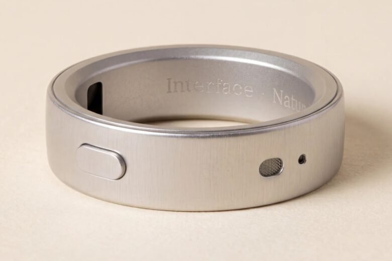 Close-up of the silver Natura Interface smart ring showing its side button and microphone openings