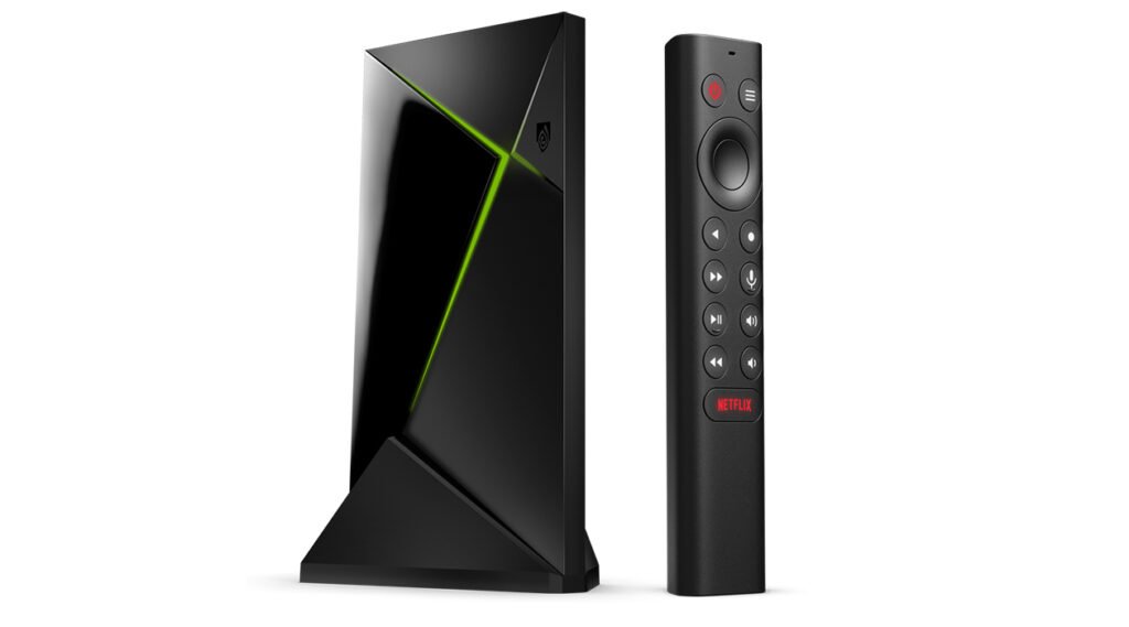 Black Nvidia Shield TV Pro streaming box standing beside its triangular remote control