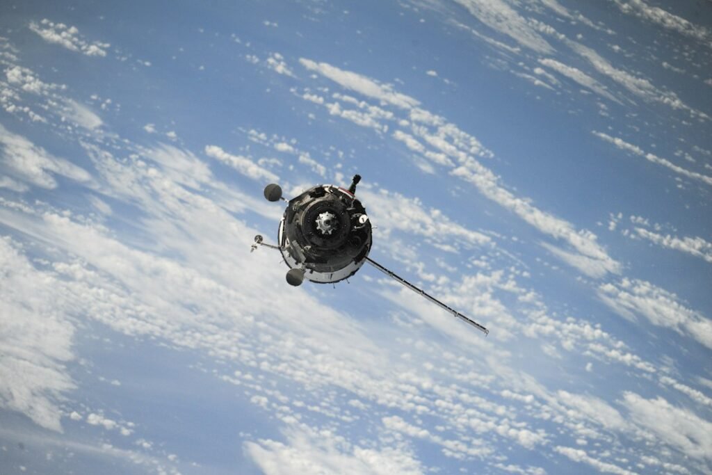 A spacecraft orbiting above Earth’s cloud-covered surface. Photo: NASA via Unsplash.