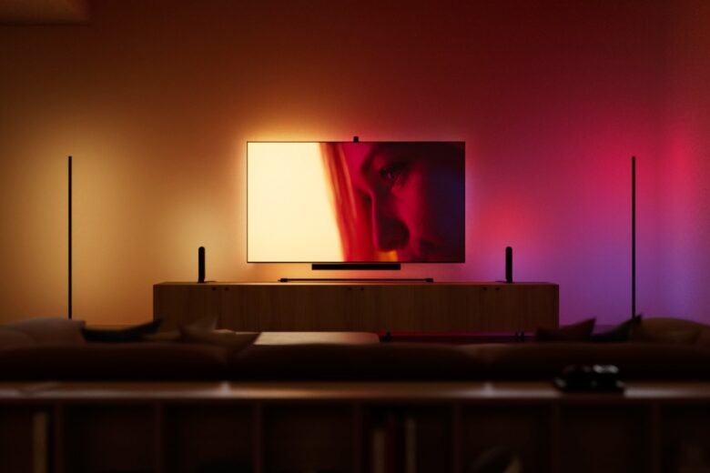 Television room illuminated with synchronized Philips Hue gradient lighting in red, amber and purple