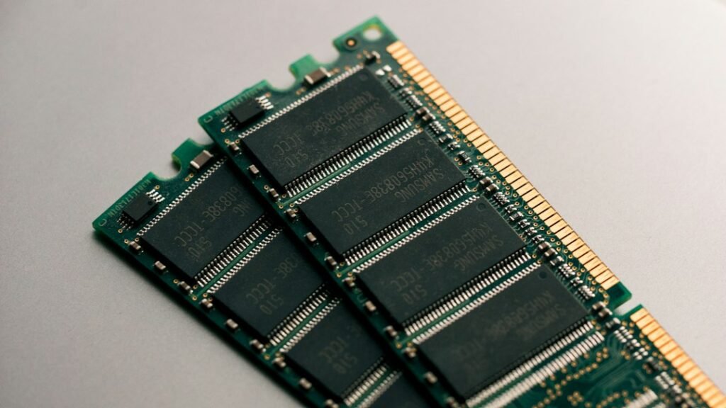 Two Samsung RAM memory modules with black chips and gold contacts. Photo: Harrison Broadbent via Unsplash.