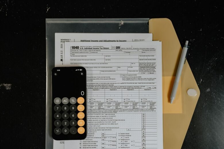 Federal tax forms on a desk with a calculator, pen and notebook