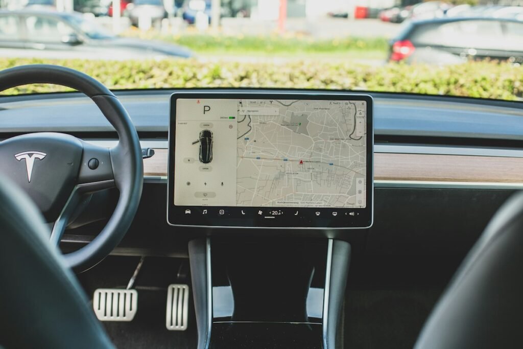 Modern vehicle interior with a large central touchscreen displaying navigation and car controls