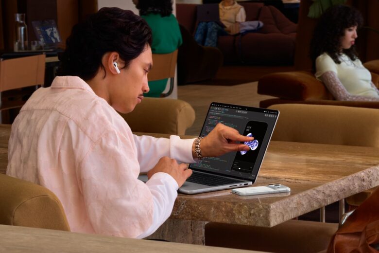 A person touching the display of Apple’s MacBook Pro with PROLED XDR Display