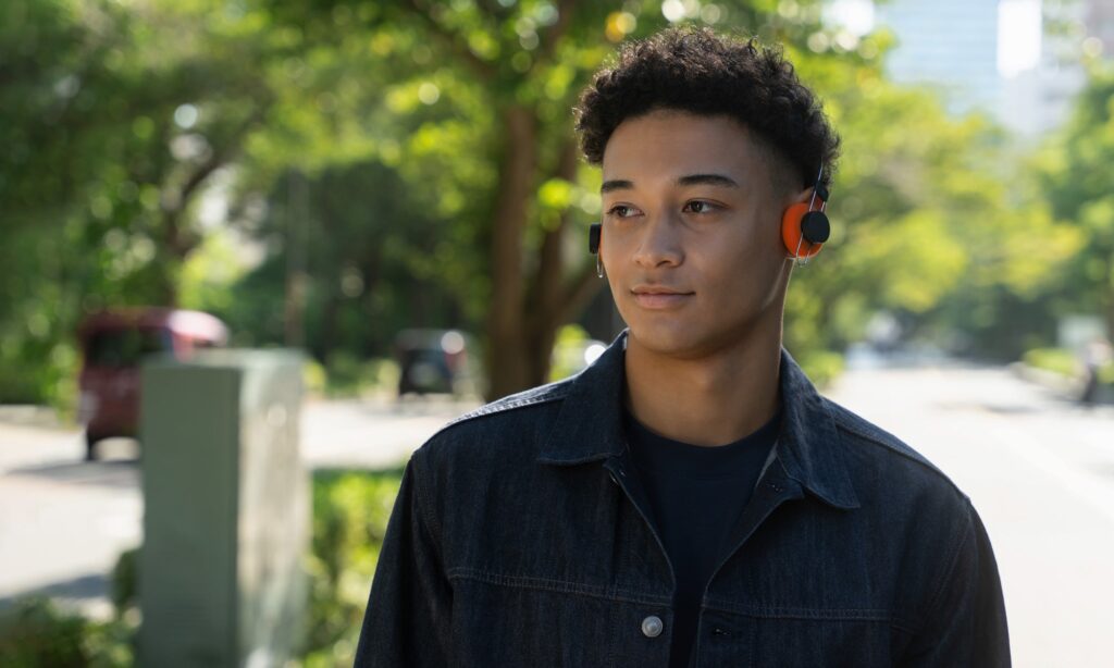 Person wearing Final Porta ultralight wireless headphones with orange ear pads