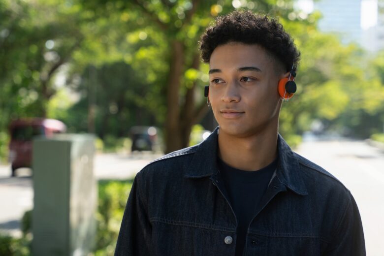 Person wearing Final Porta ultralight wireless headphones with orange ear pads